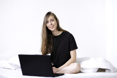 Portrait of smiling young woman using mobile phone