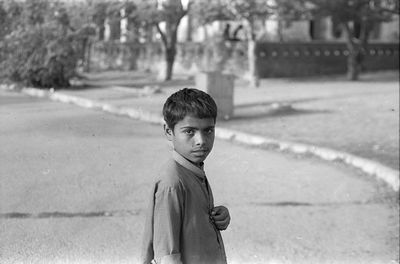 Portrait of young woman standing on road