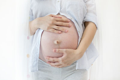 Midsection of woman touching mirror