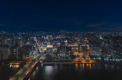 Aerial nocturn view of the azumabashi bridge on sumida river leading to the skyscrapers of asakusa