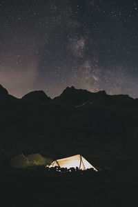 Tent at night agains the milky way over the mountains sierra de gredos