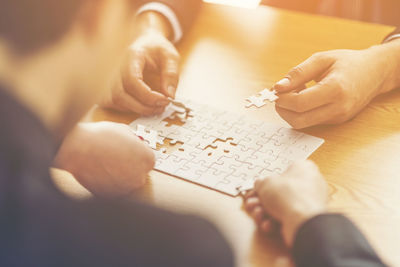 High angle view of people holding hands on table