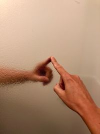 Close-up of hand touching wall