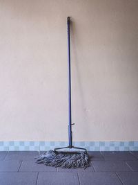 Cross on sidewalk against wall