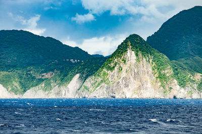 Scenic view of sea and mountains against sky