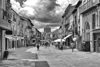 People walking on street amidst buildings in city