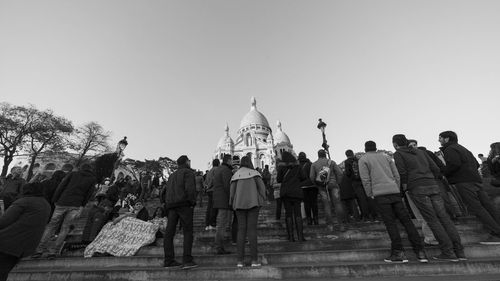 Low angle view of people on temple against clear sky