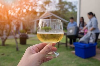 Close-up of hand holding glass of white wine