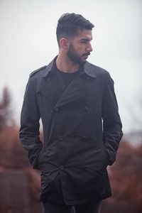 Young man standing against sky