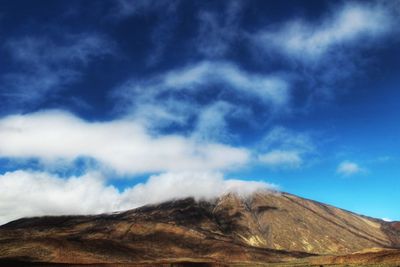 Low angle view of mountain against blue sky