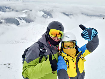 Portrait of smiling woman skiing on snow covered landscape