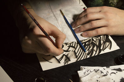 Close-up of human hands drawing on paper