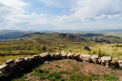 Scenic view of field against cloudy sky