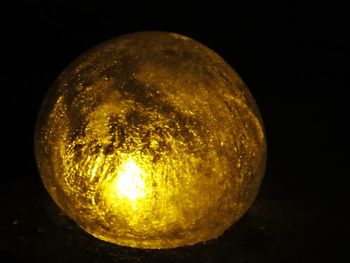 Close-up of yellow lamp against black background