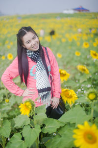 Portrait of woman standing on sunflower field