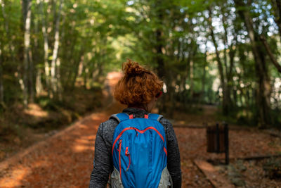 Rear view of woman standing in forest