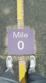 Low section of man standing on road