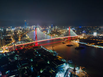 High angle view of illuminated bridge and buildings at night