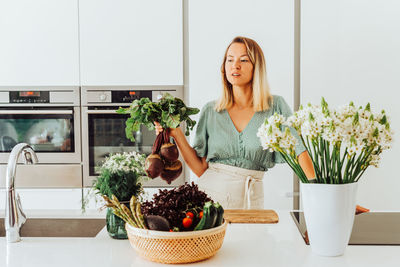 Young woman holding fresh potted plants