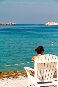 Rear view of woman looking at sea against sky