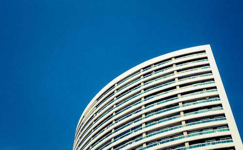 Low angle view of skyscraper against clear blue sky