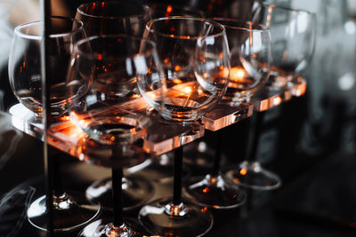 Close-up of wineglasses on rack at table