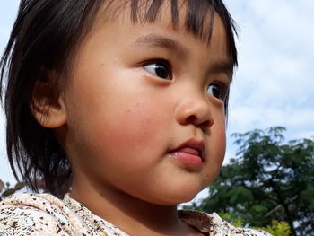 Close-up of cute girl looking away