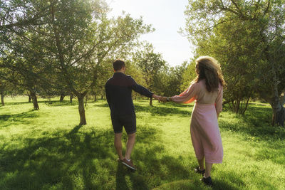 Rear view of couple standing on field