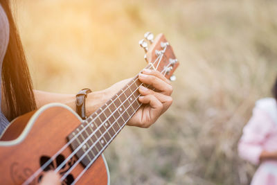 Midsection of woman playing guitar