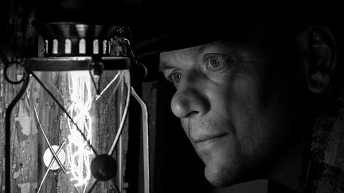 Close-up of man looking at illuminated light