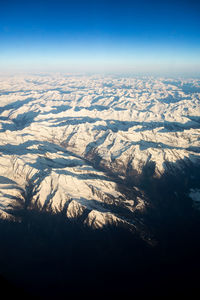 Aerial view of snowcapped mountains against sky