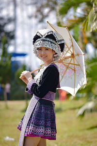 Girl holding umbrella standing outdoors