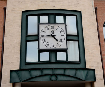 Low angle view of clock on window