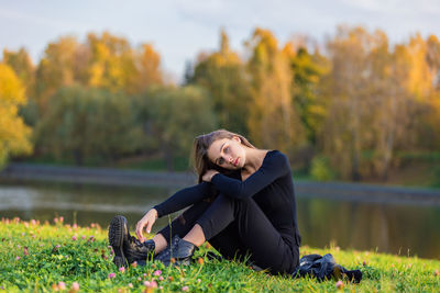 Portrait of young woman sitting on field