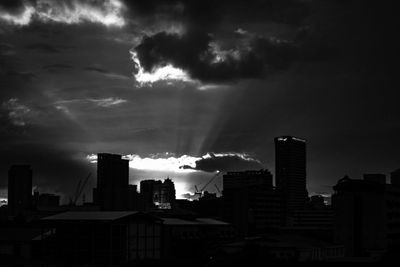 Skyscrapers in city against cloudy sky