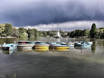 Boats moored in city against sky