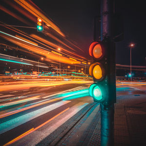 Illuminated stoplight against sky at night