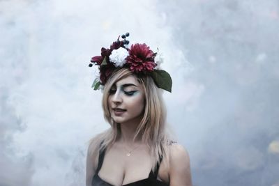 Close-up of beautiful woman wearing flowers while standing outdoors