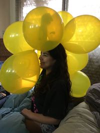 Young woman with yellow balloons