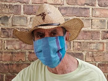 Portrait of man wearing hat against wall