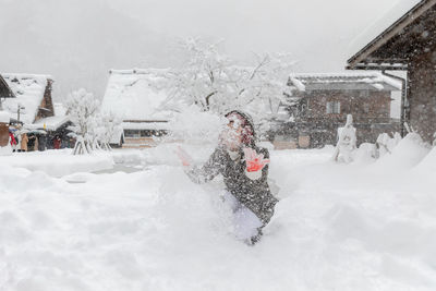 Woman covered with snow on building