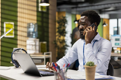 Friends using laptop while sitting at cafe