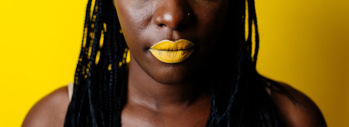 Close-up of woman face against yellow background