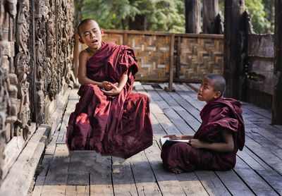 Full length of boy sitting at temple