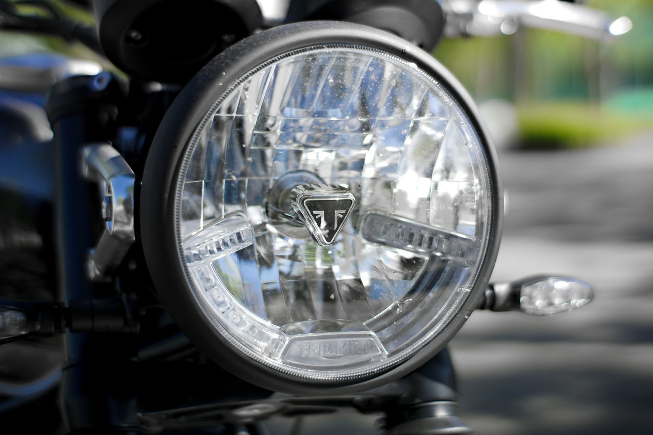 close-up, focus on foreground, mode of transportation, transportation, land vehicle, motorcycle, glass - material, headlight, no people, lighting equipment, transparent, day, reflection, car, outdoors, motor vehicle, retro styled, shiny, vehicle part, technology, chrome
