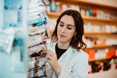 Young woman looking away while standing in store