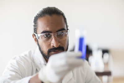 Young man scientist with lab coat checking a sample