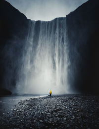Tourist looking at majestic waterfall