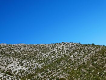 Low angle view of mountain against blue sky