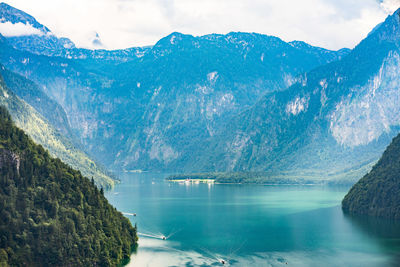 Scenic view of lake by mountains against sky